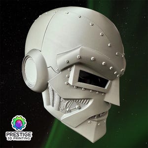 Può includere: Un casco argentato e dettagliato con una visiera rettangolare e dettagli rivettati. Il casco ha un design angolare distintivo con un mento e guance prominenti. Il logo "PRESTIGE 3D PRINTING" è visibile.