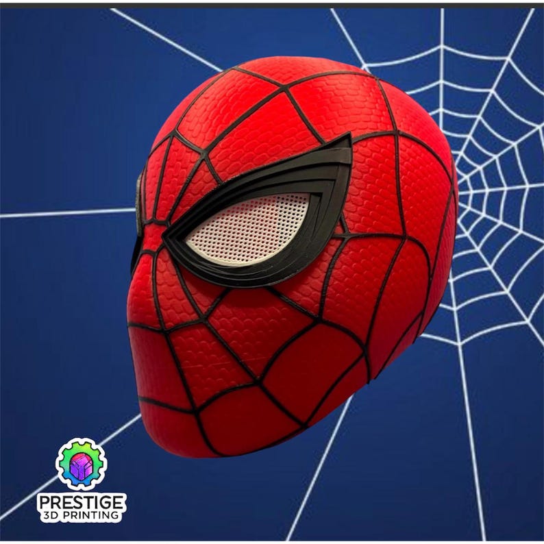 Puede incluir: Una m&aacute;scara roja de Spider-Man con telara&ntilde;as negras y detalles de ojos. La m&aacute;scara tiene una superficie texturizada y est&aacute; sobre un fondo azul con un dise&ntilde;o de telara&ntilde;a blanca. El logotipo de Prestige 3D Printing est&aacute; en la esquina inferior izquierda.
