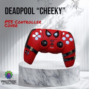 May include: Red and black PlayStation controller cover with a Deadpool design. The cover features a red and black pattern with a Deadpool mask on the front. The text "DEADPOOL "CHEEKY" PS5 CONTROLLER COVER" is displayed above the controller.