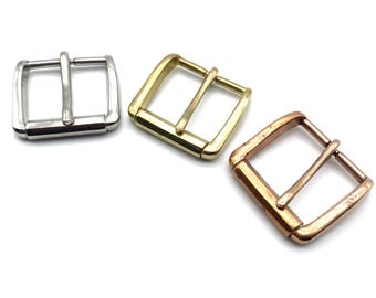 May include: Three metal belt buckles in different finishes: silver, brass, and copper.