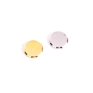 May include: Two round, metallic objects on a white background. One is gold-colored, the other is silver. Both have a shiny, reflective surface and a slightly raised edge. The objects appear to be small, possibly decorative elements or components.