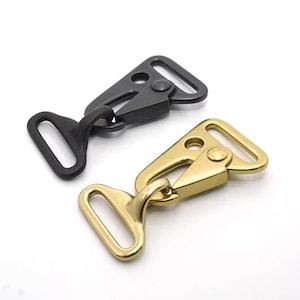 May include: Two metal swivel hooks, one black and one gold, are displayed against a white background. Each hook features a rectangular loop and a triangular plate with a swivel mechanism, designed for attaching straps or other hardware.