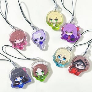 以下が含まれることがあります： アニメスタイルのキャラクターが描かれたアクリルチャーム8個セット。各チャームはピンク、紫、緑、赤などの鮮やかな色で、それぞれユニークなデザインです。黒いストラップに銀色の留め金が付いており、携帯電話やバッグに取り付けるのに最適です。
