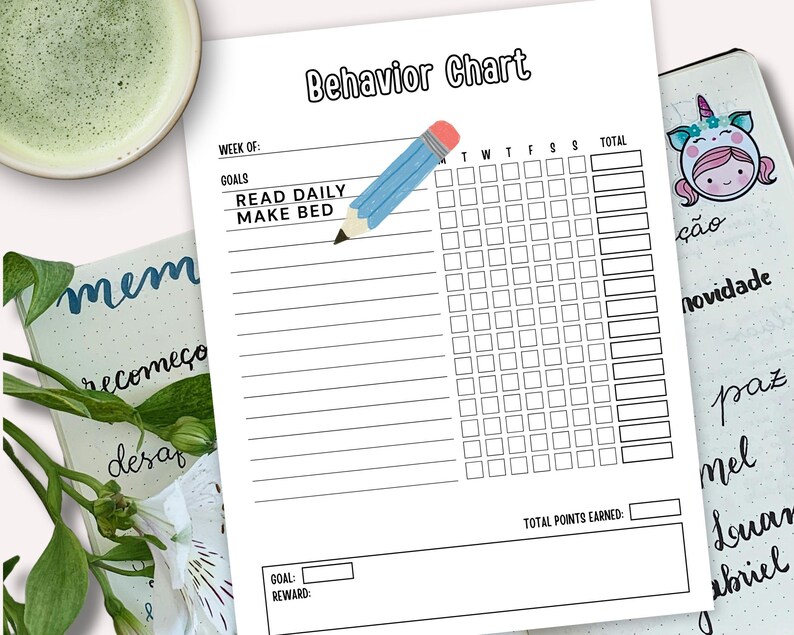 Puede incluir: Un "Cuadro de comportamiento" en blanco y negro con los objetivos "Leer a diario" y "Hacer la cama". Un l&aacute;piz azul est&aacute; dibujado en el cuadro. Una taza de t&eacute; verde y un diario con la palabra "mem" est&aacute;n en el fondo.