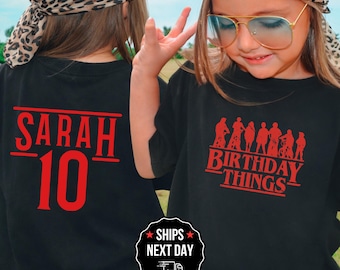 May include: Black t-shirts with red text. One shirt says "SARAH 10" and the other says "BIRTHDAY THINGS" with a silhouette graphic. The shirts are worn by a person wearing a leopard print bandana and aviator sunglasses.