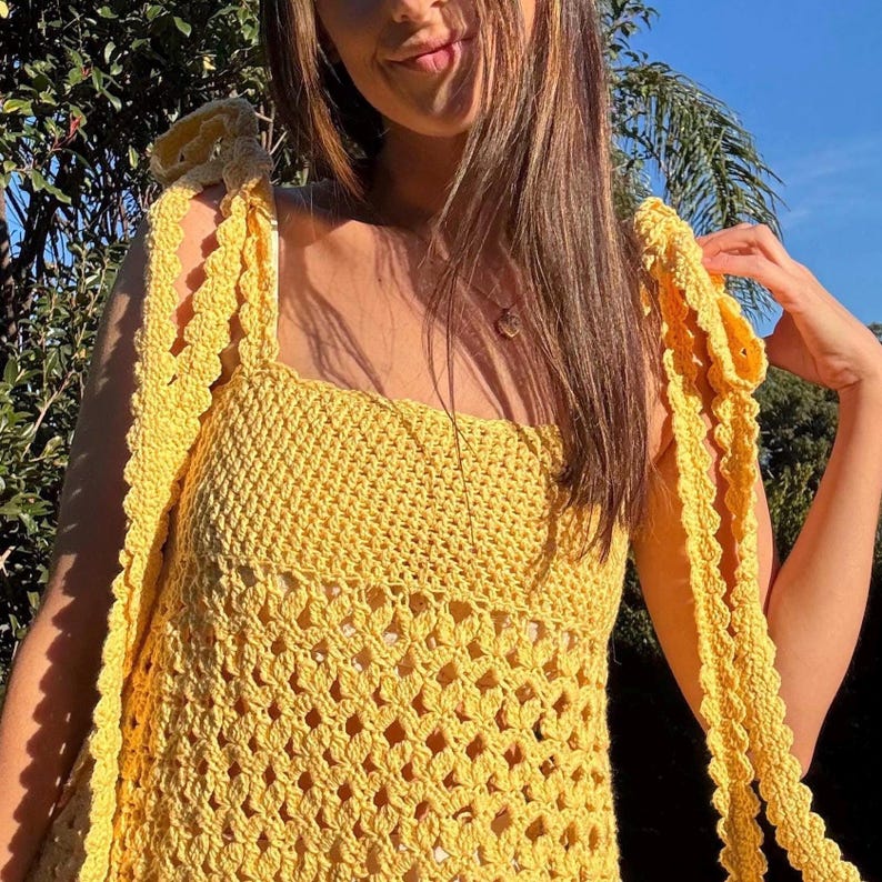 Peut inclure: Un haut en crochet jaune vif avec une encolure carr&eacute;e et des liens aux &eacute;paules. Le haut pr&eacute;sente un motif de point ajour&eacute;. Les bretelles sont longues et festonn&eacute;es. Le v&ecirc;tement est fait &agrave; la main, parfait pour l'&eacute;t&eacute;.