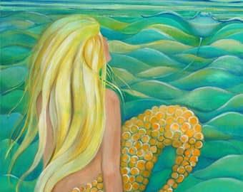 Blond mermaid with golden tail sitting watching stingray  in the blue green water