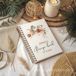 May include: A white spiral bound recipe book with a watercolor floral design in shades of brown, orange, and green. The text "Jennifer's Recipe Book 05.10.20XX" is printed on the cover.
