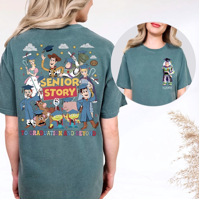 May include: Teal t-shirt with a colourful graphic of animated characters, the text "SENIOR STORY" and "TO GRADUATION AND BEYOND." A smaller image shows a character with a graduation cap and the word "NAME."