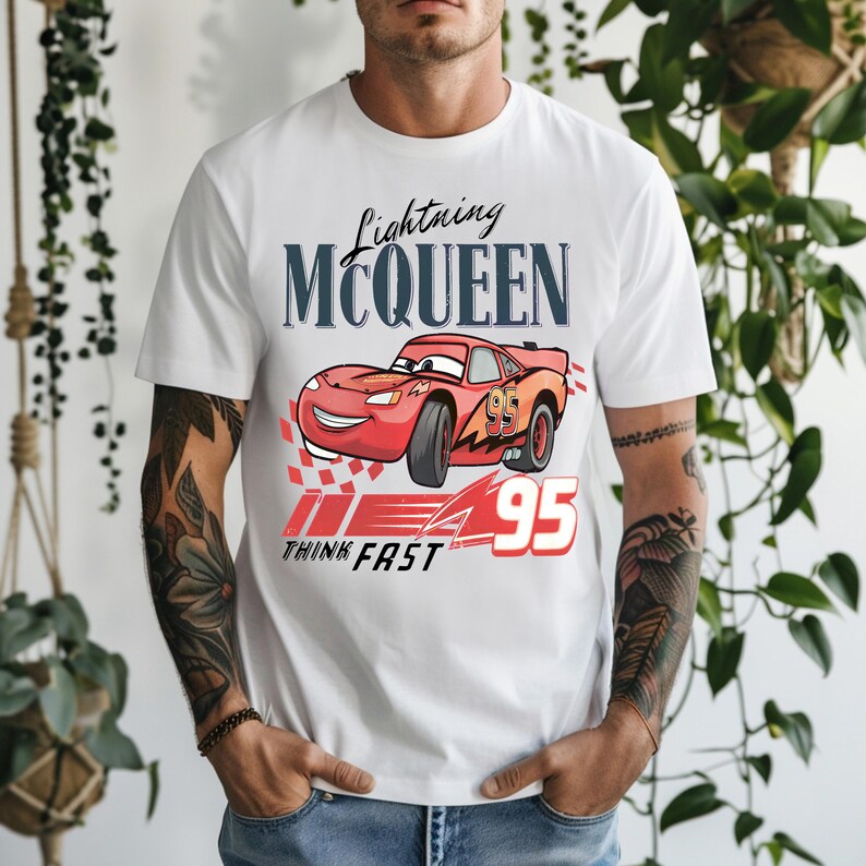 May include: White t-shirt featuring a graphic of Lightning McQueen from the Cars movie. The design includes the text "Lightning McQueen" above a red race car with the number "95" and the words "Think Fast".