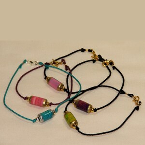 Sample bracelets made using hand made paper beads and hand twisted pure silk cord in different colours.