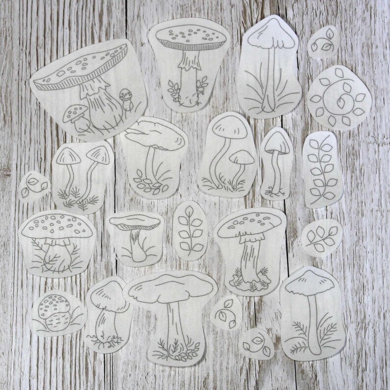 22 Fungi Stick & Stitch embroidery pattern designs on a table top.