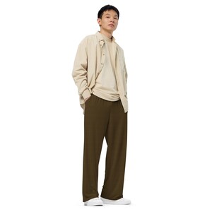 Pode incluir: Uma pessoa vestindo uma camisa bege de botões sobre uma camiseta branca e calças verde-escuras.