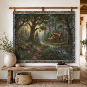 May include: A rectangular woven wall tapestry featuring a detailed forest scene with a small cabin, a winding stream, and large trees. The tapestry has a fringed edge and is suspended from a wooden rod. The color palette includes deep greens, browns, and soft golden light.
