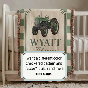 May include: A beige and green tractor-themed baby blanket with the name "WYATT" printed on it. The blanket features a green tractor illustration and a green and white checkered border. The blanket is displayed on a white crib.