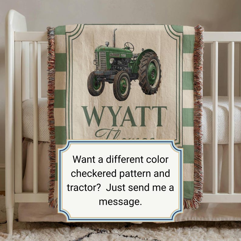 May include: A beige and green tractor-themed baby blanket with the name "WYATT" printed on it. The blanket features a green tractor illustration and a green and white checkered border. The blanket is displayed on a white crib.