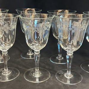 Puede incluir: Juego de siete copas de vino de cristal transparente. Cada copa presenta un diseño floral grabado en el cuenco y un tallo largo. Las copas tienen una forma clásica y elegante, ideal para servir vino.