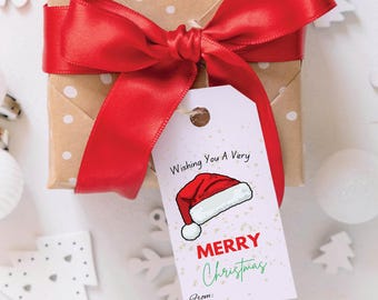 May include: White gift tag with a red Santa hat illustration and the text "Wishing You A Very Merry Christmas". The tag is tied to a brown gift box with white polka dots and a red satin ribbon.