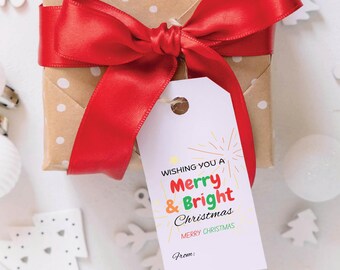 May include: A white gift tag with a red, green and yellow design that says "Wishing you a Merry & Bright Christmas" with a space for a name at the bottom. The tag is tied to a brown gift box with red polka dots and a red satin ribbon.
