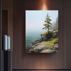 Könnte beinhalten: Ein gerahmtes Landschaftsgemälde einer Küstenlandschaft. Ein hoher Nadelbaum steht auf einer felsigen Klippe mit Blick auf das Meer. Das Wasser ist türkis und der Himmel hellblau. Das Gemälde wird an einer dunkel getäfelten Holzwand ausgestellt.