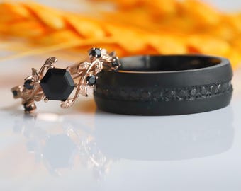 Peut inclure: Une paire d'alliances, l'une avec une pierre précieuse noire sertie dans une bande en or rose avec un motif de vigne, et l'autre une bande noire avec une rangée de pierres précieuses noires.