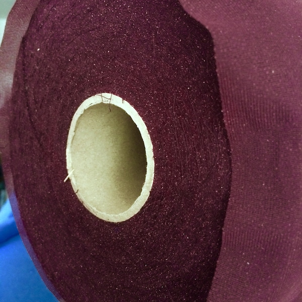 Lightweight synthetic fusible iron-on interfacing fabric in  dark purple; for garments