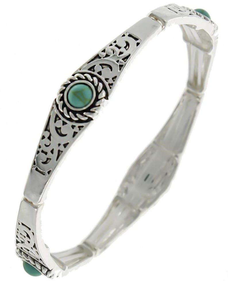 May include: Silver tone stretch bracelet with turquoise stones and an intricate filigree design.