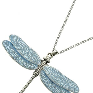 May include: A silver necklace with a blue dragonfly pendant. The dragonfly has detailed wings and a textured body.
