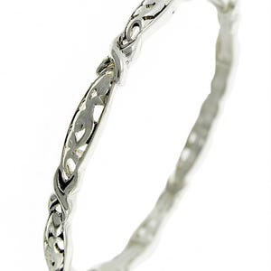 Puede incluir: Un brazalete de plata con un delicado dise&ntilde;o intrincado de hojas y vides en espiral.