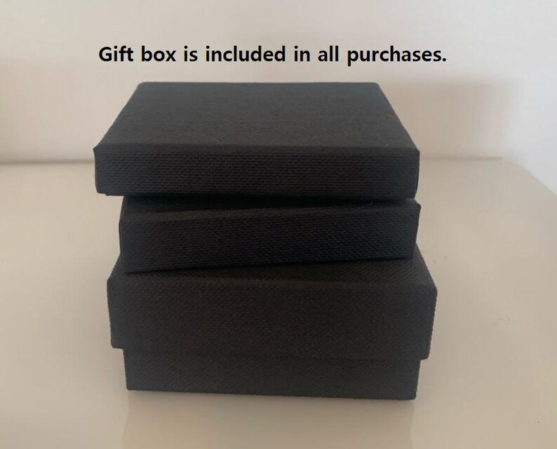 May include: Three black gift boxes stacked on top of each other. The text "Gift box is included in all purchases." is visible above the boxes.