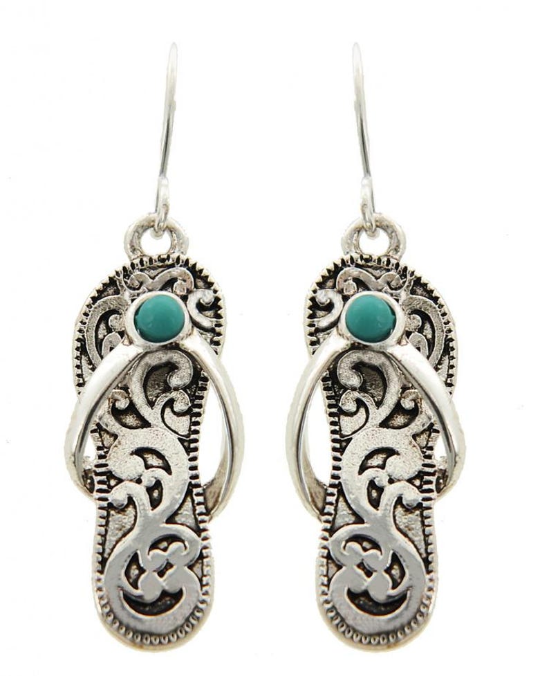 May include: Silver dangle earrings with a turquoise stone in the center of each earring. The earrings are shaped like flip flops with an intricate design.
