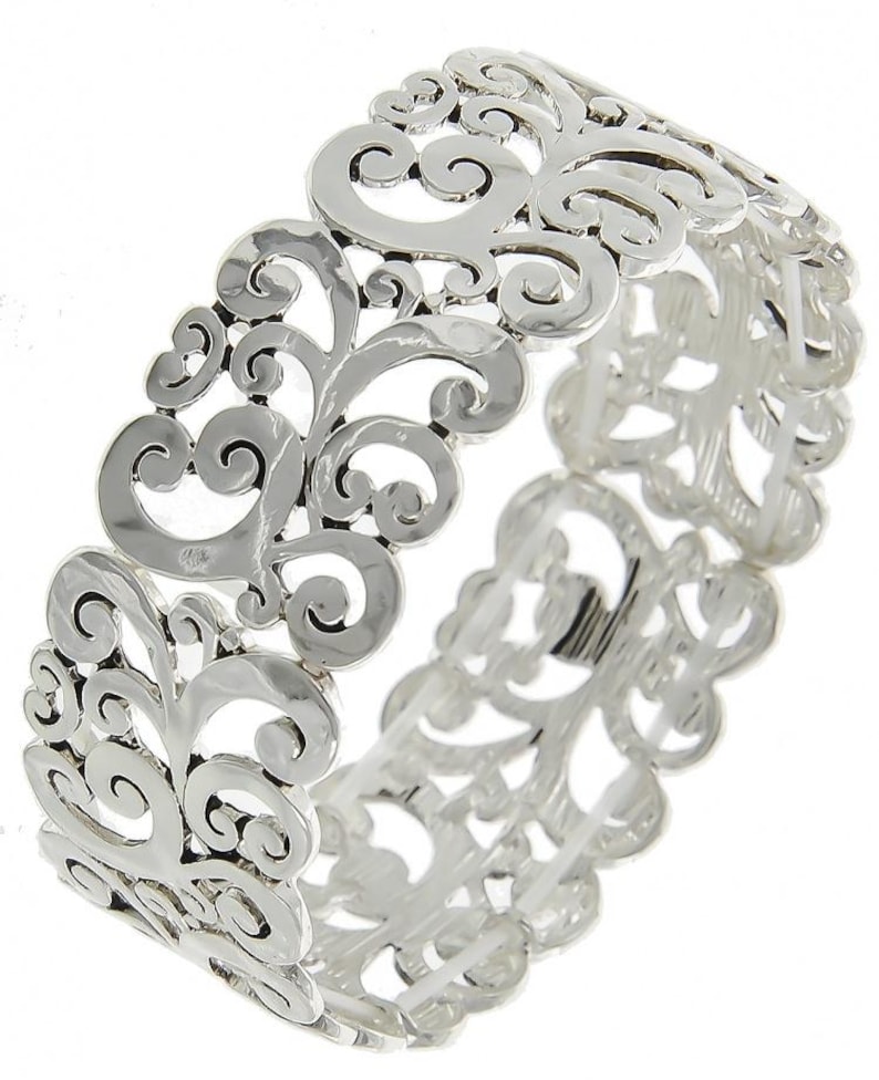 Może przedstawiać: Srebrna bransoletka typu bangle z delikatnym, skomplikowanym wzorem wirujących, kwiatowych wzor&oacute;w. Bransoletka jest otwarta i ma lekko młotkowaną fakturę.