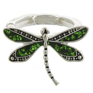 May include: A silver ring with a green glitter dragonfly design.