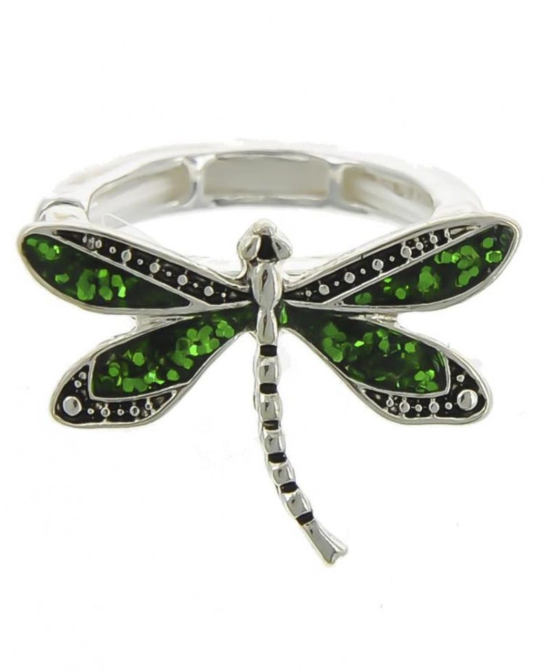 May include: A silver ring with a green glitter dragonfly design.