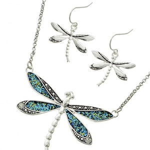 May include: A silver necklace and earrings set featuring a blue and green glitter dragonfly pendant and matching earrings.