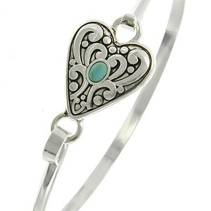 Peut inclure: Un bracelet jonc en argent avec un pendentif en forme de c&oelig;ur. Le pendentif est d&eacute;cor&eacute; d'un motif de filigrane et pr&eacute;sente une pierre turquoise au centre.