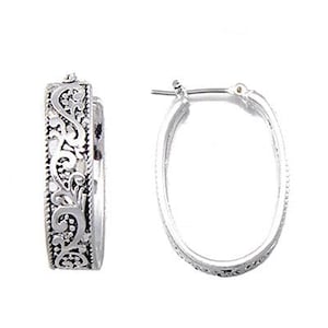 May include: A pair of silver-toned hoop earrings. One earring features an ornate, detailed design, while the other is a simple oval hoop. The detailed earring has a scrolling, floral pattern. The earrings are displayed against a white background.