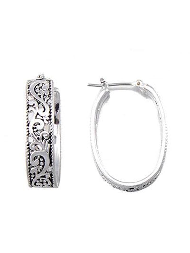 May include: A pair of silver-toned hoop earrings. One earring features an ornate, detailed design, while the other is a simple oval hoop. The detailed earring has a scrolling, floral pattern. The earrings are displayed against a white background.