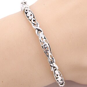 Puede incluir: Pulsera de plata con un dise&ntilde;o delicado e intrincado. La pulsera est&aacute; hecha de una cadena retorcida y calada con un patr&oacute;n floral.
