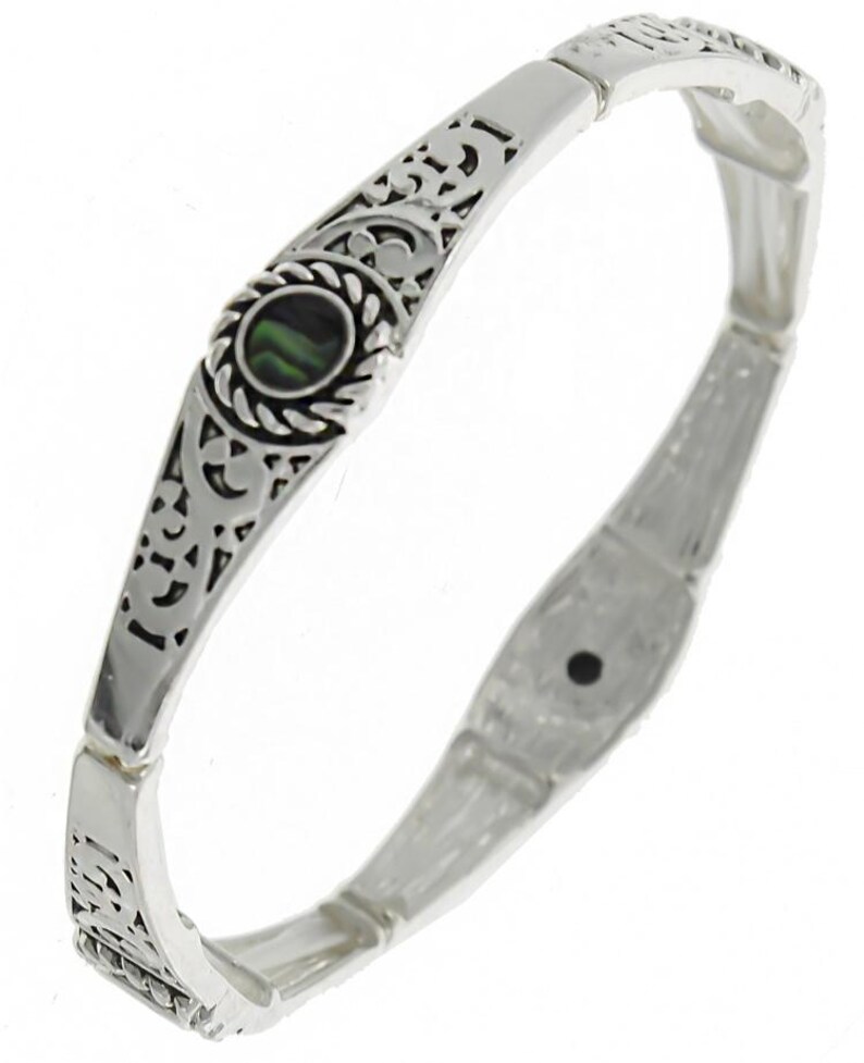 May include: Silver tone stretch bracelet with an ornate design and a green abalone shell inlay.