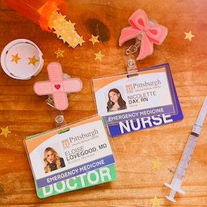 May include: A collection of medical-themed items, including two ID badges with photos and the text "Pittsburgh Emergency Medicine Nurse" and "Doctor". There's also a pink bow badge reel, a plaster-shaped badge reel, a syringe, and star-shaped confetti.