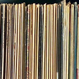 May include: A collection of vintage paperback books with various titles and authors. The books are arranged vertically and have a worn, aged appearance.