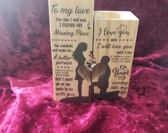 Könnte beinhalten: Zwei Holzblöcke mit graviertem Text und Silhouetten. Ein Block liest "To my love" und "Missing Piece". Der andere Block liest "I love you" und "Thank you". Die Blöcke befinden sich auf einer roten Samtoberfläche.