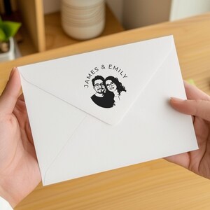 May include: A white envelope with a black circular stamp featuring a couple's portrait and the text "JAMES & EMILY".