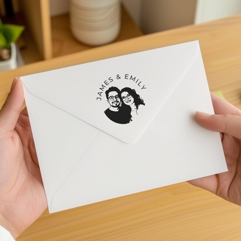 May include: A white envelope with a black circular stamp featuring a couple's portrait and the text "JAMES & EMILY".