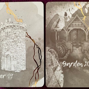 May include: Two tarot cards with gold accents. The card on the left depicts a stone tower with a door and the text "Tower 19". The card on the right shows a wooden gazebo with the text "Garden 20".