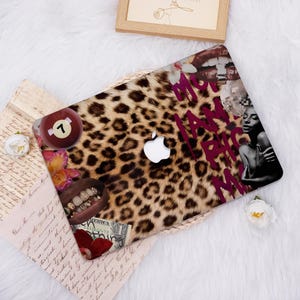May include: A laptop skin featuring a leopard print design with a white Apple logo. The skin includes images of a pool ball, lips with gold teeth, a woman, and the text "MY I AM BIG MY".