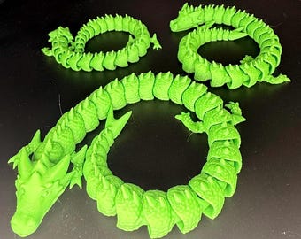 May include: Three articulated, bright green dragon toys are displayed on a dark surface. The dragons are segmented, allowing for flexible posing. Each dragon has a detailed head, body, and tail, showcasing a 3D-printed design. The vibrant green color makes them visually striking.