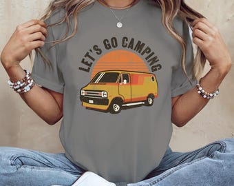 May include: A gray t-shirt with a vintage-style graphic of a yellow van and the text "Let's Go Camping".