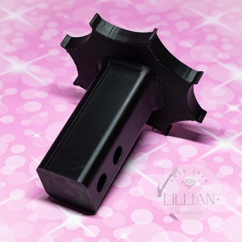 May include: Black plastic hitch adapter with a star-shaped base. The adapter has two holes on the side.